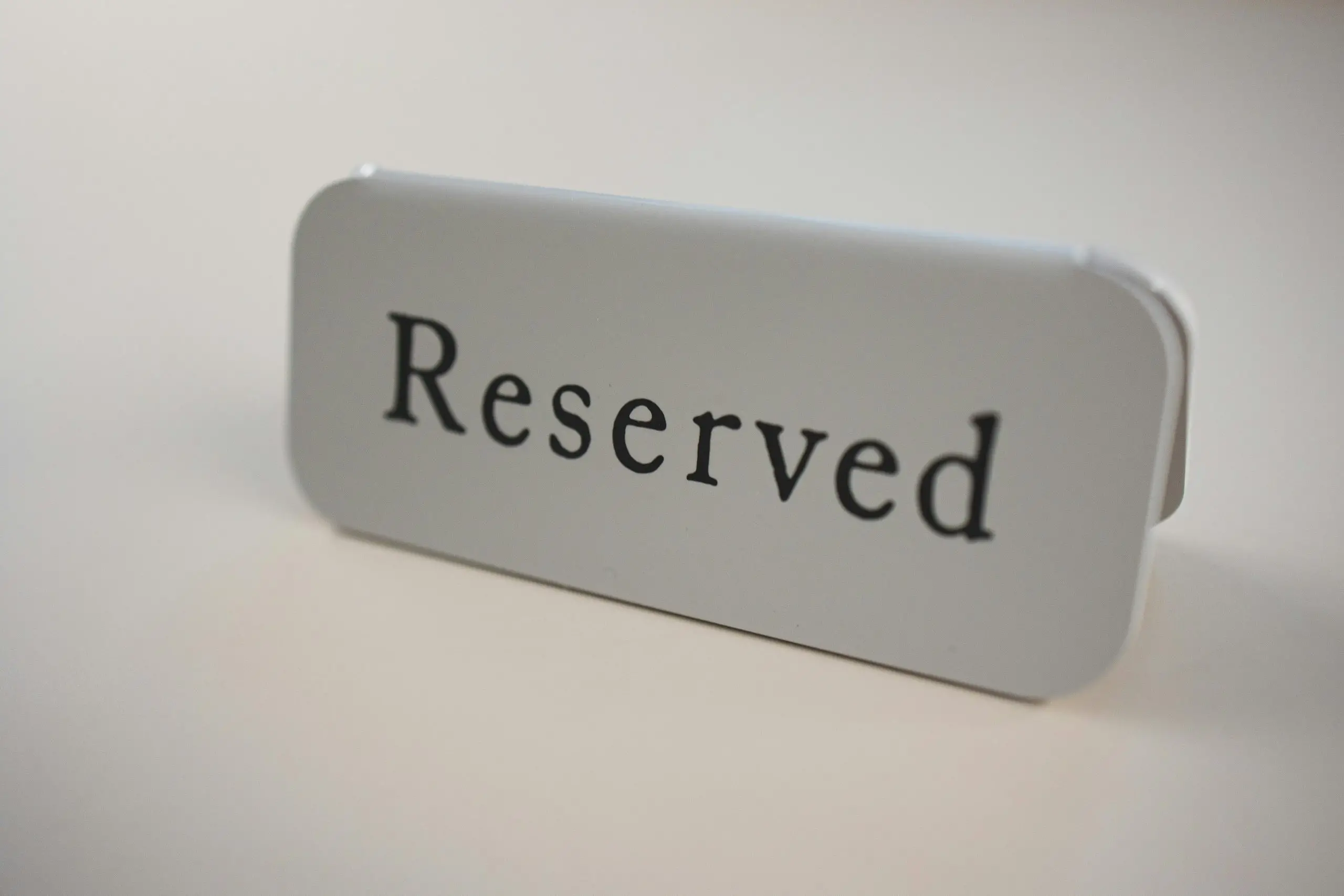 Close-up of a minimalist reserved sign on a table, ideal for restaurants or events.